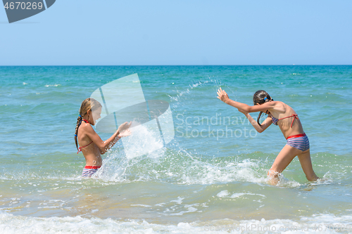 Image of Girls splash on each other on the sea coast