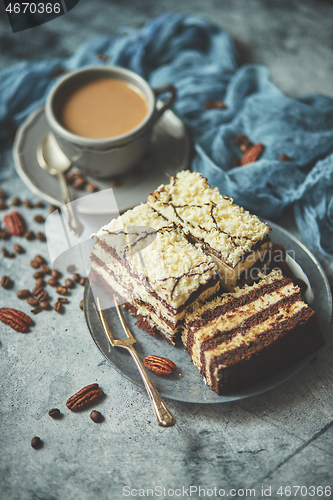 Image of Homemade layered cake sprinkled with white chocolate. Served wit