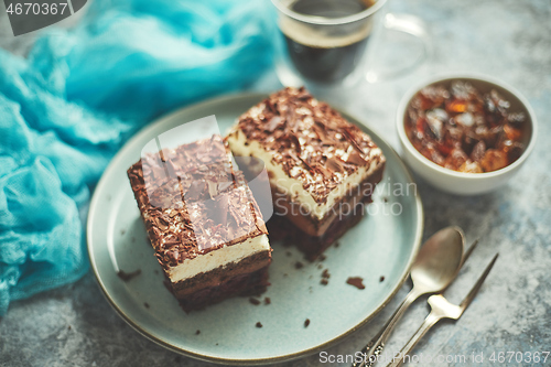 Image of Close up on chocolate pieces of layered cake. Sprinkled with milk chocolate