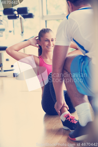 Image of young sporty woman with trainer exercise in fitness gym