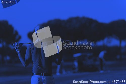 Image of golfer from back at course looking to hole in distance