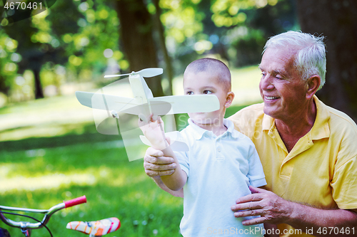 Image of grandfather and child have fun  in park