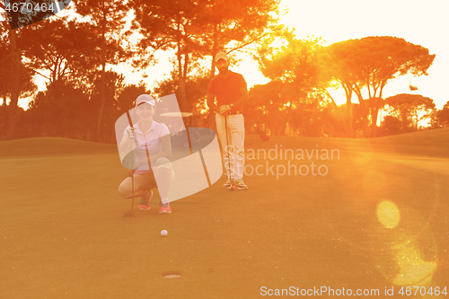 Image of couple on golf course at sunset