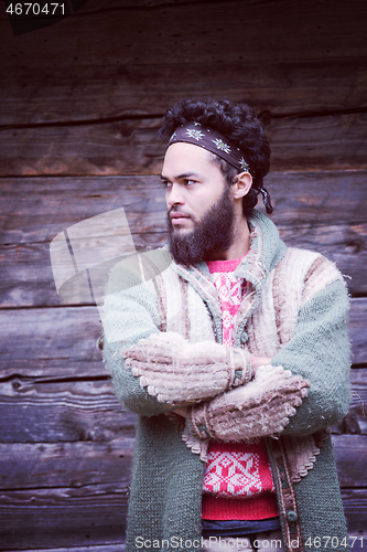 Image of portrait of young hipster in front of wooden house