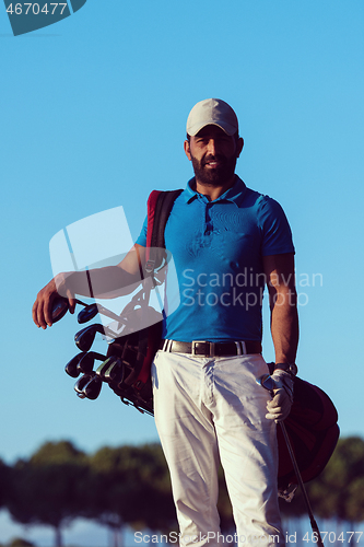 Image of golfer  portrait at golf course on sunset