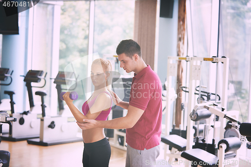 Image of young sporty woman with trainer exercise weights lifting