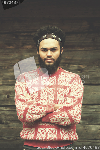 Image of portrait of young hipster in front of wooden house