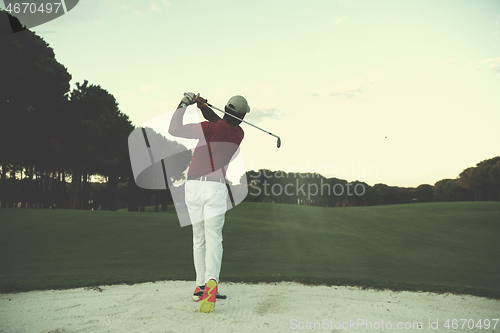 Image of golfer hitting a sand bunker shot on sunset