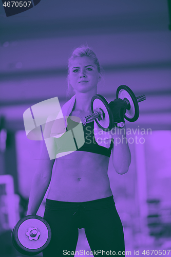 Image of lifting some weights and working on her biceps in a gym