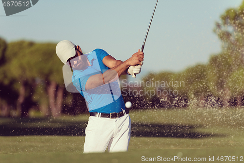 Image of pro golfer hitting a sand bunker shot