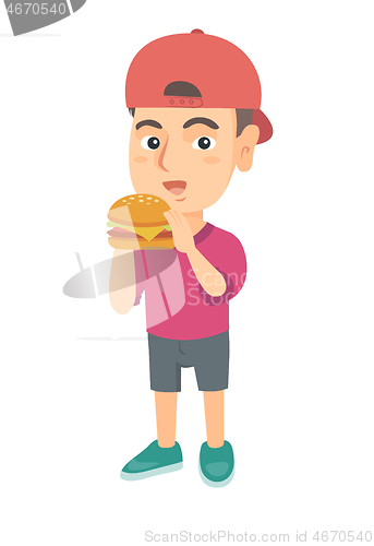 Image of Little caucasian boy eating a hamburger.