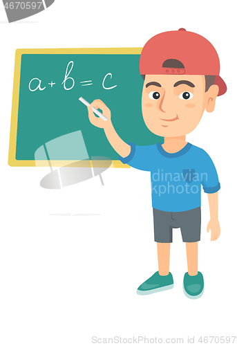 Image of Caucasian schoolboy writing on the blackboard.