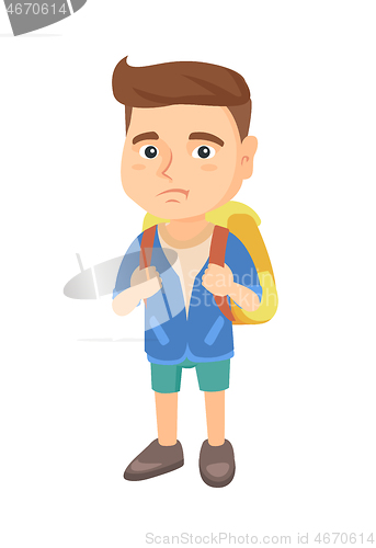 Image of Little caucasian sad schoolboy carrying a backpack