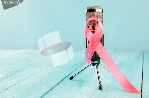 Image of the text world cancer day and a pink ribbon on a table background