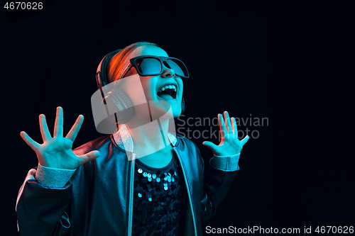 Image of Young girl with headphones enjoying music