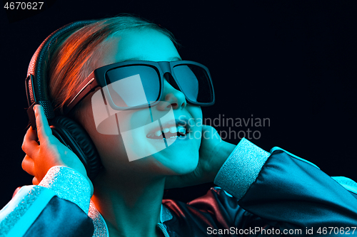 Image of Young girl with headphones enjoying music