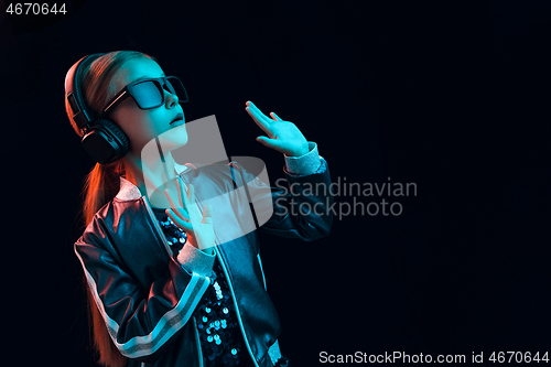 Image of Young girl with headphones enjoying music