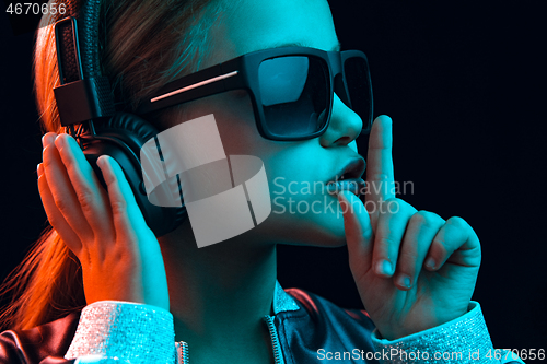 Image of Young girl with headphones enjoying music
