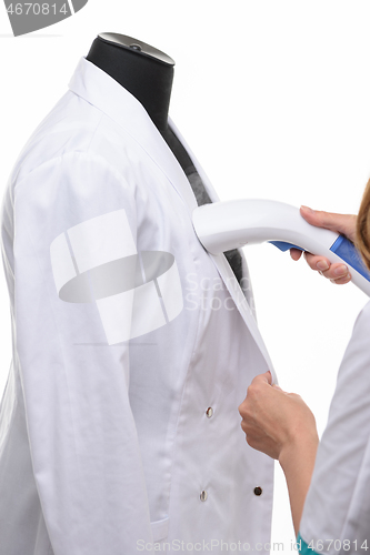 Image of steaming medical clothing on a manicure on a white background