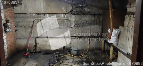 Image of Basement renovation process. Dark dirty room with pipes