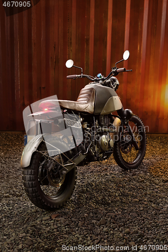 Image of Custom scrambler motorbike on a rusty container background.