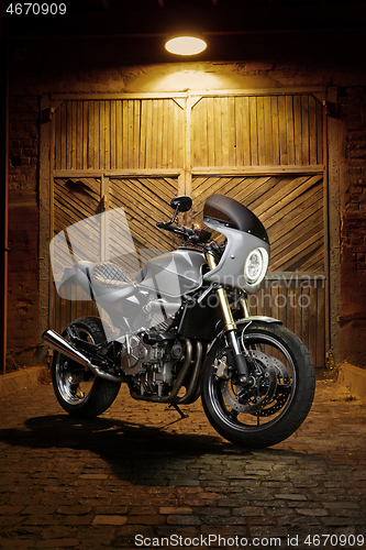 Image of Custom caferacer motorbike on an old garage door background.