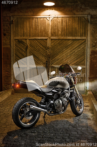 Image of Custom caferacer motorbike on an old garage door background.