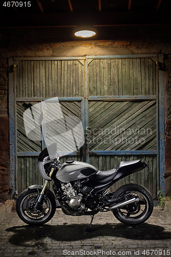 Image of Custom caferacer motorbike on an old garage door background.