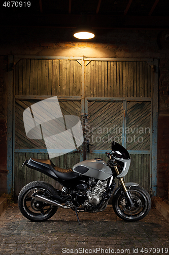 Image of Custom caferacer motorbike on an old garage door background.