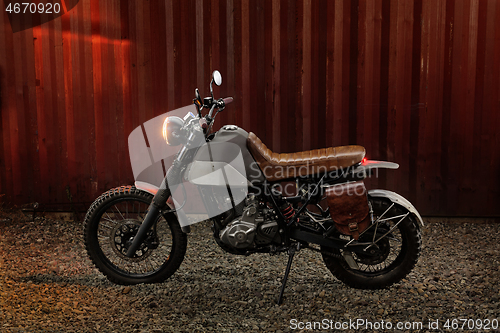 Image of Custom scrambler motorbike on a rusty container background.