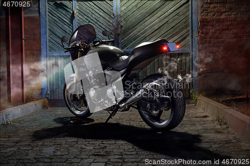 Image of Custom caferacer motorbike on an old garage door background.