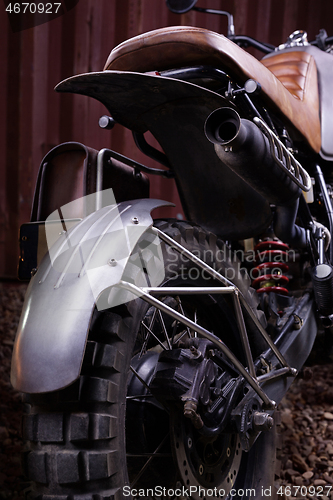 Image of Custom scrambler motorbike on a rusty container background.