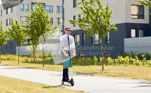 Image of businessman with shopping bag riding scooter