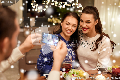 Image of friends having christmas dinner and taking picture