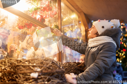 Image of girl choosing christmas decorations at market