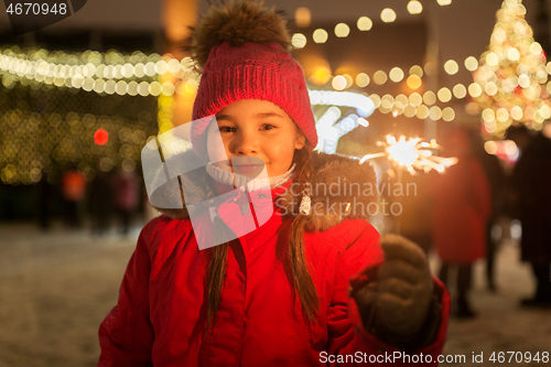 Image of happy girl with sparkler at christmas market