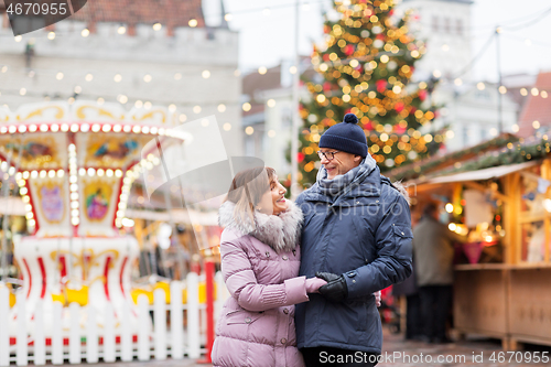 Image of happy senior couple hugging at christmas market