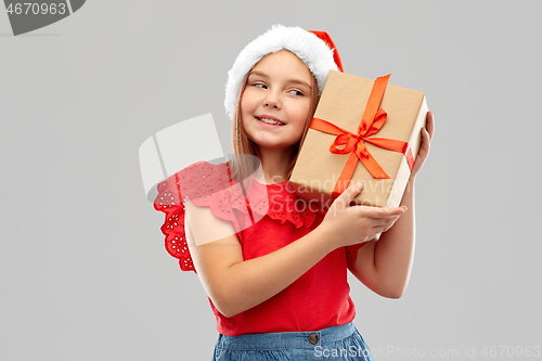 Image of smiling girl in snata hat with christmas gift