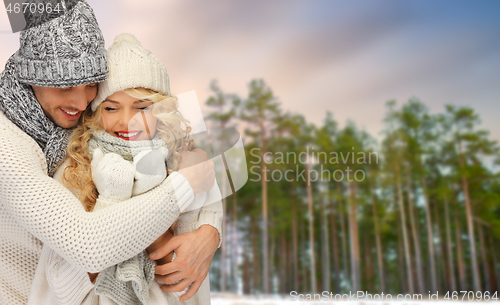 Image of couple hugging over winter forest background