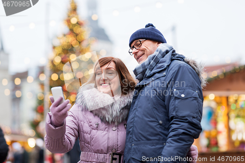 Image of senior couple taking selfie at christmas market