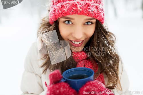 Image of happy young woman with tea cup in winter