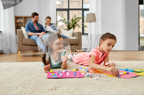 Image of happy sisters doing arts and crafts at home