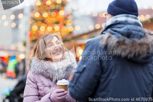 Image of senior couple with coffee at christmas market