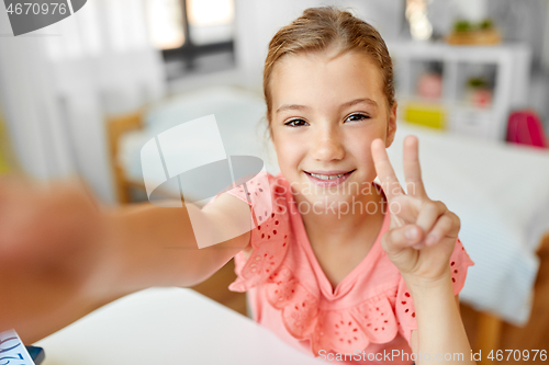 Image of happy girl taking selfie at home