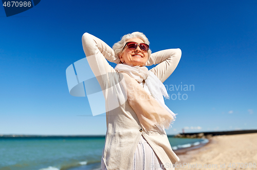 Image of portrait of senior woman in sunglasses on beach