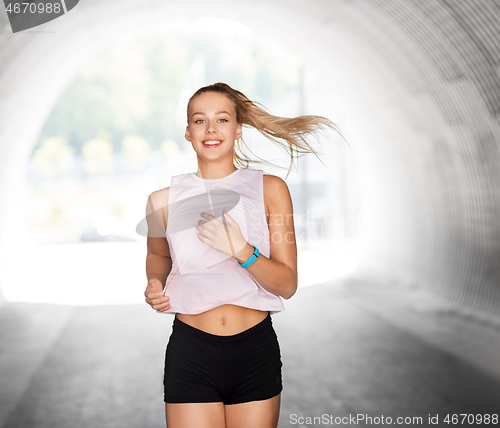 Image of happy teenage girl running outdoors