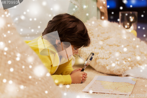 Image of boy with magnifier and map in kids tent at home