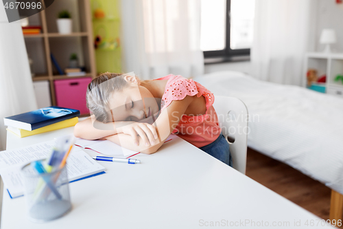 Image of tired student girl sleeping on table at home