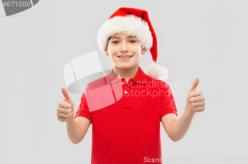 Image of smiling boy in santa helper hat showing thumbs up