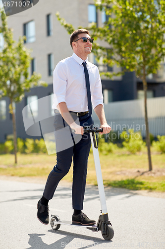 Image of young businessman riding electric scooter outdoors